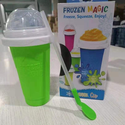 Green Slushy Maker Cup with a spoon and packaging labeled 'Frozen Magic' on a light surface.