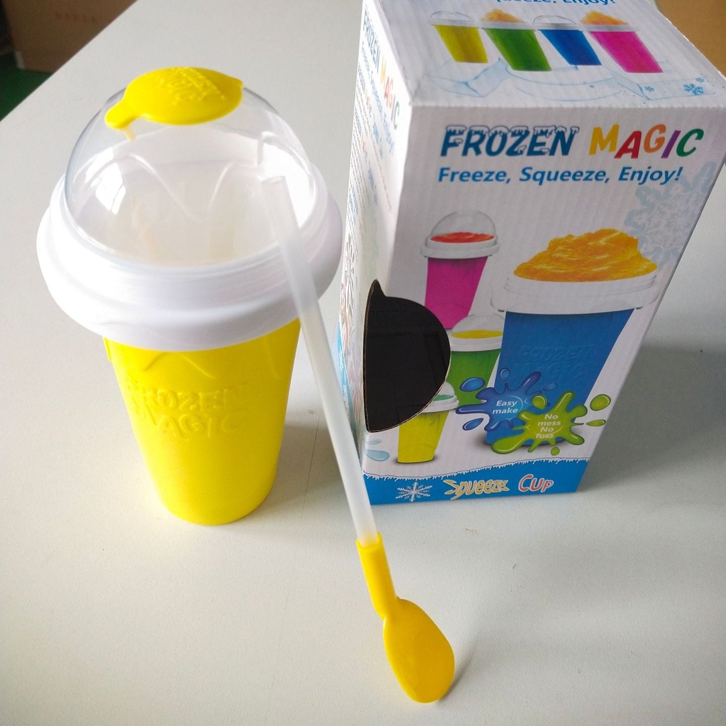 Yellow and white Slushy Maker Cup with packaging on a table