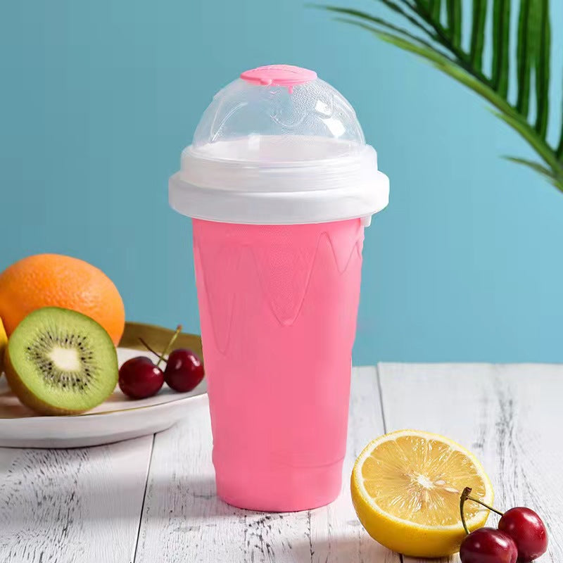 Pink silicone cup with lid on a table with fruits