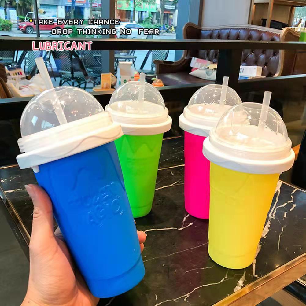 Colorful ice cream cups with lids held by a hand on a table in a cafe.