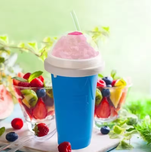 Blue cup with pink slushie and straw, surrounded by fruit bowls on a light green background
